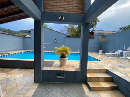 a patio with a swimming pool with a potted plant at Casa em Juquehy flat 02 in São Sebastião