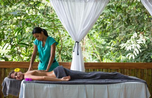 Una mujer recibiendo un masaje de una mujer en una cama en Vista Celestial, en Uvita