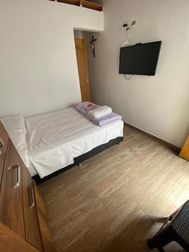 a small bedroom with a bed and a flat screen tv at habitaciones a 15min aeropuerto rionegro in Rionegro