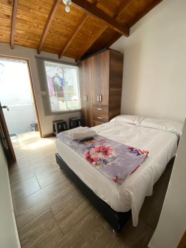 a bedroom with a bed with a blanket on it at habitaciones a 15min aeropuerto rionegro in Rionegro