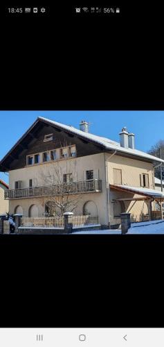 un grand bâtiment avec une clôture devant lui dans l'établissement Le tout en double, à Gérardmer