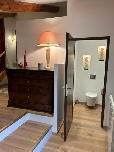 a room with a dresser and a lamp and a mirror at Le mas des petites forêts in Chabeuil