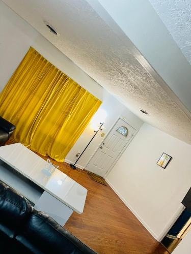 a living room with a yellow curtain and a table at A place like nowhere else in Lawton