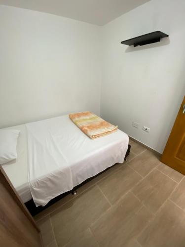 a bedroom with a white bed with a blanket on it at habitaciones a 15min aeropuerto rionegro in Rionegro