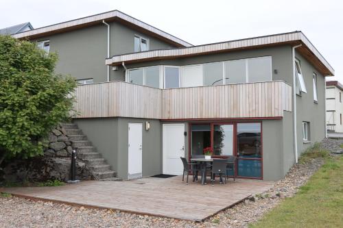 une maison avec une table et des chaises sur un patio dans l'établissement Guesthouse Dyngja, à Höfn