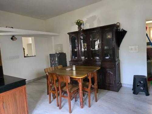 a dining room with a wooden table and chairs at Vallayil House in Kottayam
