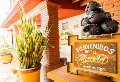 a sign in front of a hotel lobby with plants at Hotel Magda in Oaxaca City