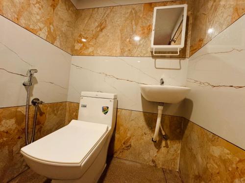a bathroom with a toilet and a sink at Marari Helen Villa in Mararikulam