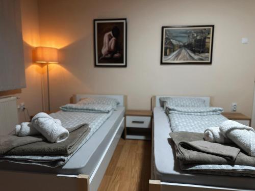 two beds in a room with towels on them at Royal Apartmani in Negotin
