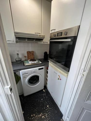 une petite cuisine avec un lave-linge et un lave-linge dans l'établissement Appartement champs Élysées vue sur Tour Eiffel, à Paris