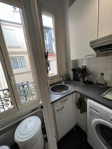 Il comprend une petite cuisine avec un lavabo et des toilettes. dans l'établissement Appartement champs Élysées vue sur Tour Eiffel, à Paris