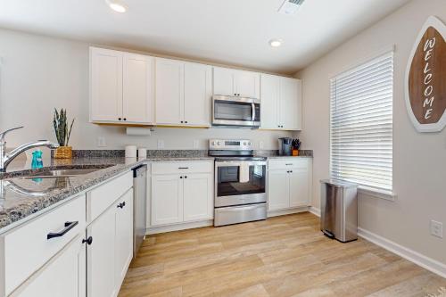a kitchen with white cabinets and a stainless steel appliances at Coastal Pines in Ocean Isle Beach