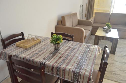 a table with a table cloth and a vase with flowers on it at Beautiful Salalah Beach Apartments - 1 by Beautiful Salalah Tours in Salalah