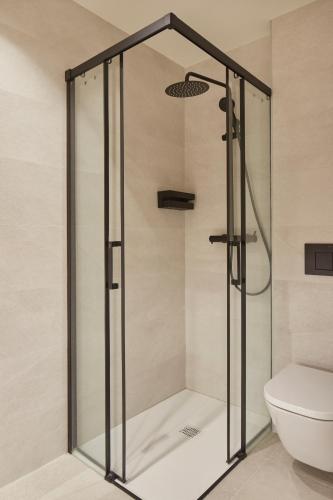 a glass shower in a bathroom with a toilet at Pensión Pakeleku in Urnieta