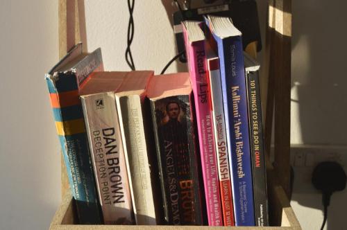 a row of books sitting on a shelf at Beautiful Salalah Beach Apartments - 1 by Beautiful Salalah Tours in Salalah