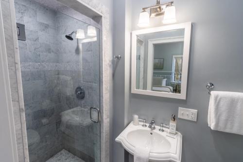 a bathroom with a shower and a sink and a mirror at The Outlook Inn in Newport