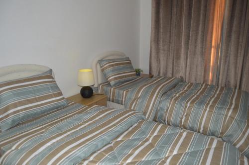 two beds sitting next to each other in a bedroom at Beautiful Salalah Beach Apartments - 1 by Beautiful Salalah Tours in Salalah