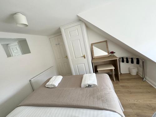 a bedroom with a bed with two towels on it at Waterloo Townhouse Inverness in Inverness