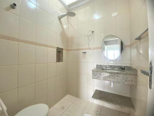 ein Badezimmer mit Toilette und Spiegel in der Unterkunft Apartamento no Centro ótima localização in Bertioga