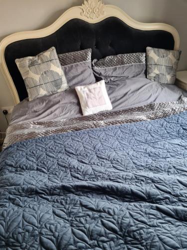 a bed with a blue comforter and pillows on it at Super king bed room A in Sherborne Saint John