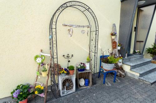 un arco con piante in vaso sul lato di un edificio di Ferienwohnung Glückauf a Peiting