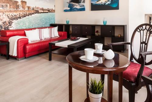 sala de estar con sofá rojo y mesa en Apartamento Vistabella, en Cádiz