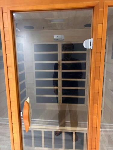 a glass door with a reflection of a person in it at Ravine Retreat - 3RM Suite, 2BD, 1 WR, Pool, Sauna in Whitby