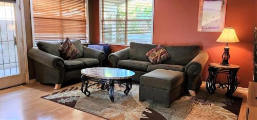 a living room with two couches and a table at Quiet desert getaway with ping-pong, BBQ, citrus in Phoenix