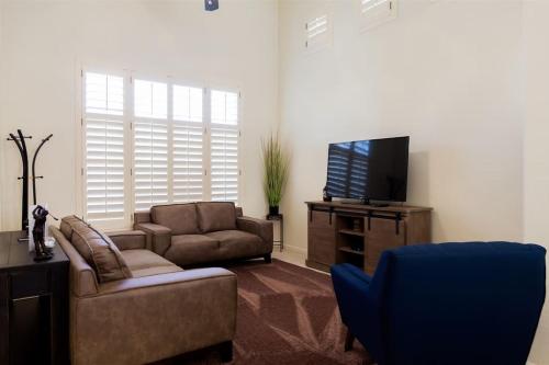 un salon avec un canapé et une télévision dans l'établissement Gated Ocotillo house, pool heater, BBQ, golf views, à Chandler