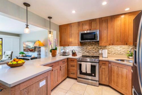 a kitchen with wooden cabinets and stainless steel appliances at Alii Kai II 10A in Princeville