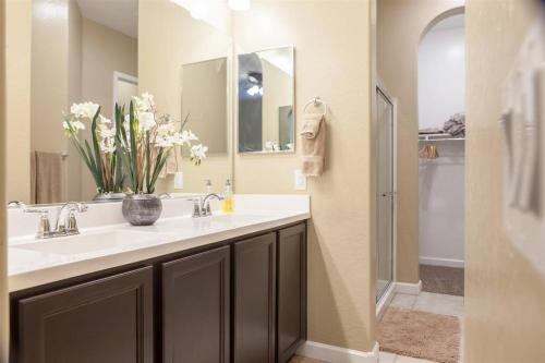 a bathroom with a sink with a vase of flowers at Gated townhouse with heated pool, hot tub, near US60 in Mesa