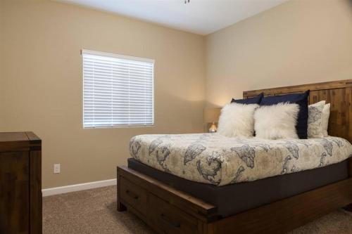 a bedroom with a bed with pillows and a window at Gated townhouse with heated pool, hot tub, near US60 in Mesa