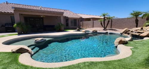 a swimming pool in the yard of a house at Cozy spacious house, pool heater, spa, firepit in Peoria