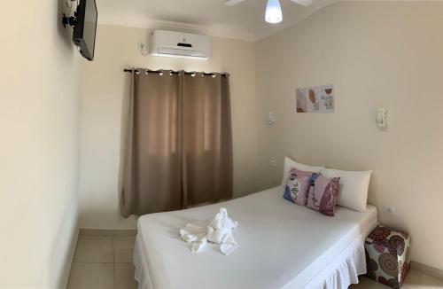 ein Schlafzimmer mit einem großen weißen Bett mit einem Fenster in der Unterkunft Pousada Recanto Som do Mar in Caraguatatuba