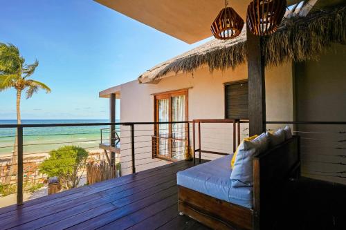 a room with a balcony with a view of the ocean at La Zebra Tulum, a Small Luxury Hotel in Tulum