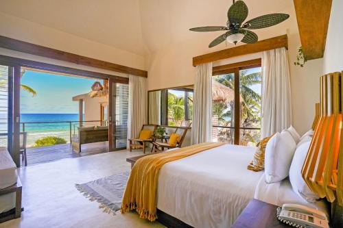 a bedroom with a bed and a view of the ocean at La Zebra Tulum, a Small Luxury Hotel in Tulum