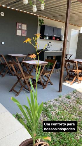 a patio with a table and chairs and a plant at Pousada Recanto Som do Mar in Caraguatatuba