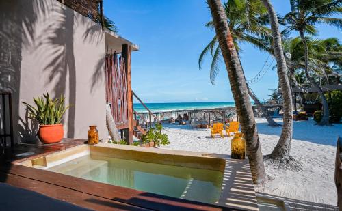 a swimming pool on the beach next to a resort at La Zebra Tulum, a Small Luxury Hotel in Tulum