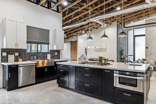 a kitchen with black cabinets and stainless steel appliances at Modern Industrial-Near Old Town in Scottsdale