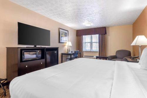 a hotel room with a bed and a flat screen tv at Best Western Campbellsville Inn in Campbellsville
