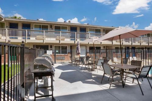 a patio with tables and chairs and an umbrella at Best Western Shadow Inn in Woodland