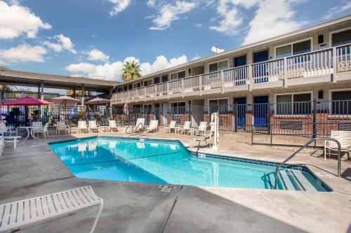a pool in front of a hotel with tables and chairs at Best Western Shadow Inn in Woodland