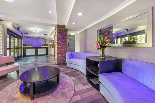 a living room with purple couches and a table at Best Western PLUS Avita Suites in Torrance