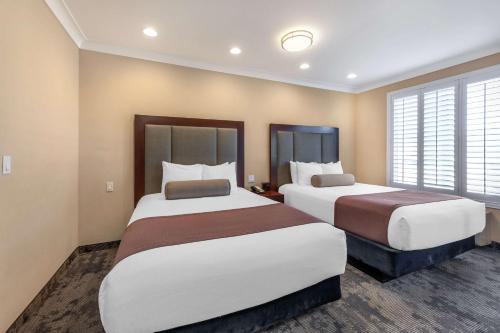 a hotel room with two beds and windows at Best Western PLUS Avita Suites in Torrance