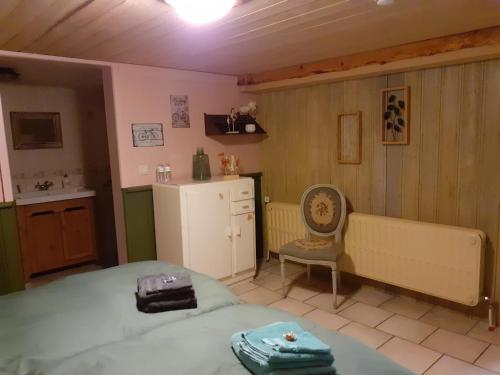 a bedroom with a bed and a small kitchen at De Patuljak in Houffalize