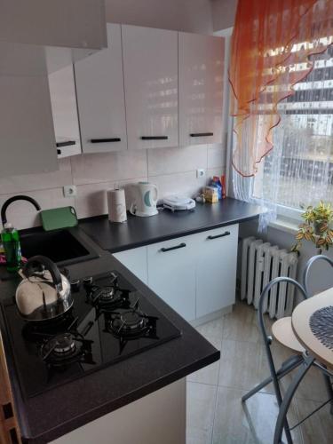 a kitchen with a stove and a counter top at Apartament Komfort in Przemyśl