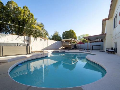 a large blue swimming pool next to a building at Spacious house with pool heater, hot tub, billiards in Phoenix