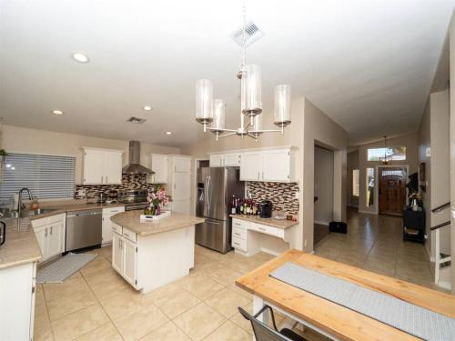 a large kitchen with white cabinets and a table at Spacious house with pool heater, hot tub, billiards in Phoenix