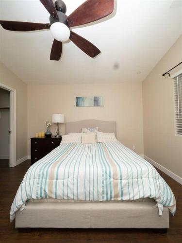 a bedroom with a bed with a ceiling fan at Spacious house with pool heater, hot tub, billiards in Phoenix