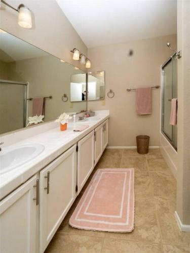 a bathroom with two sinks and a large mirror at Spacious house with pool heater, hot tub, billiards in Phoenix